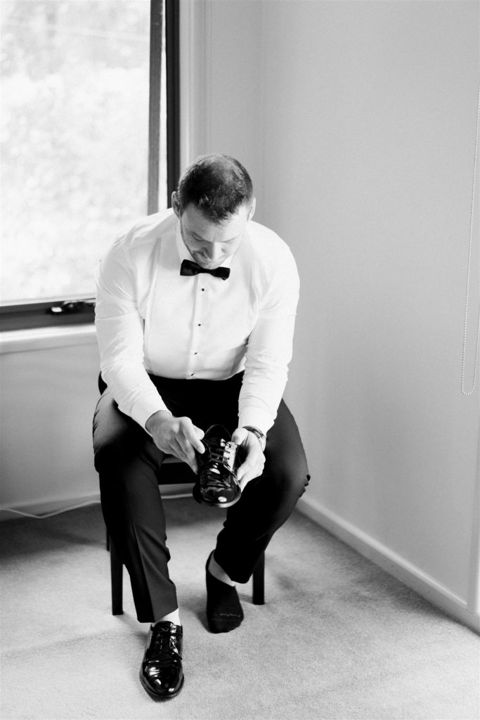 Groom getting ready, putting on his shoes