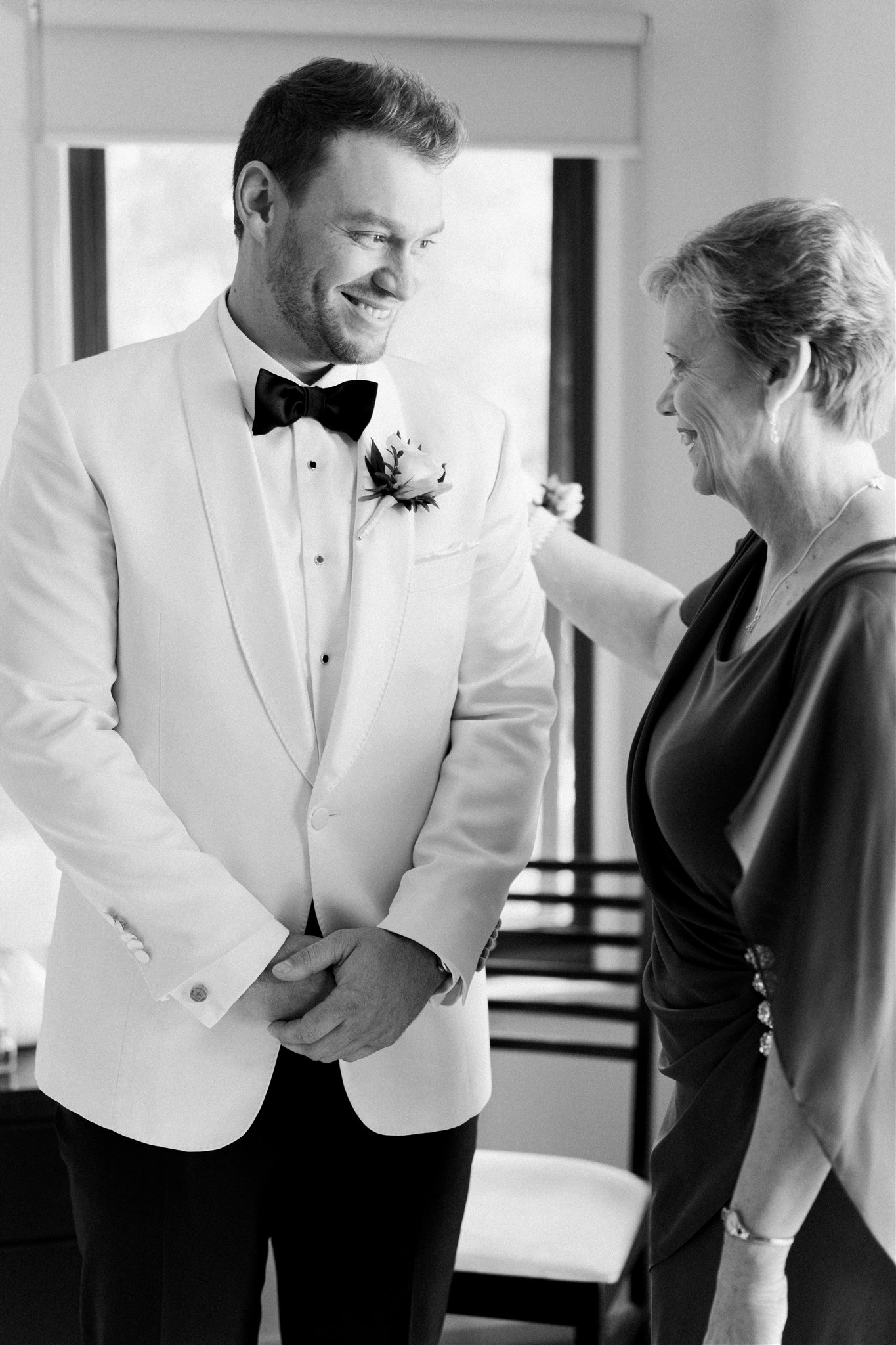 Groom getting ready smiling at his mother