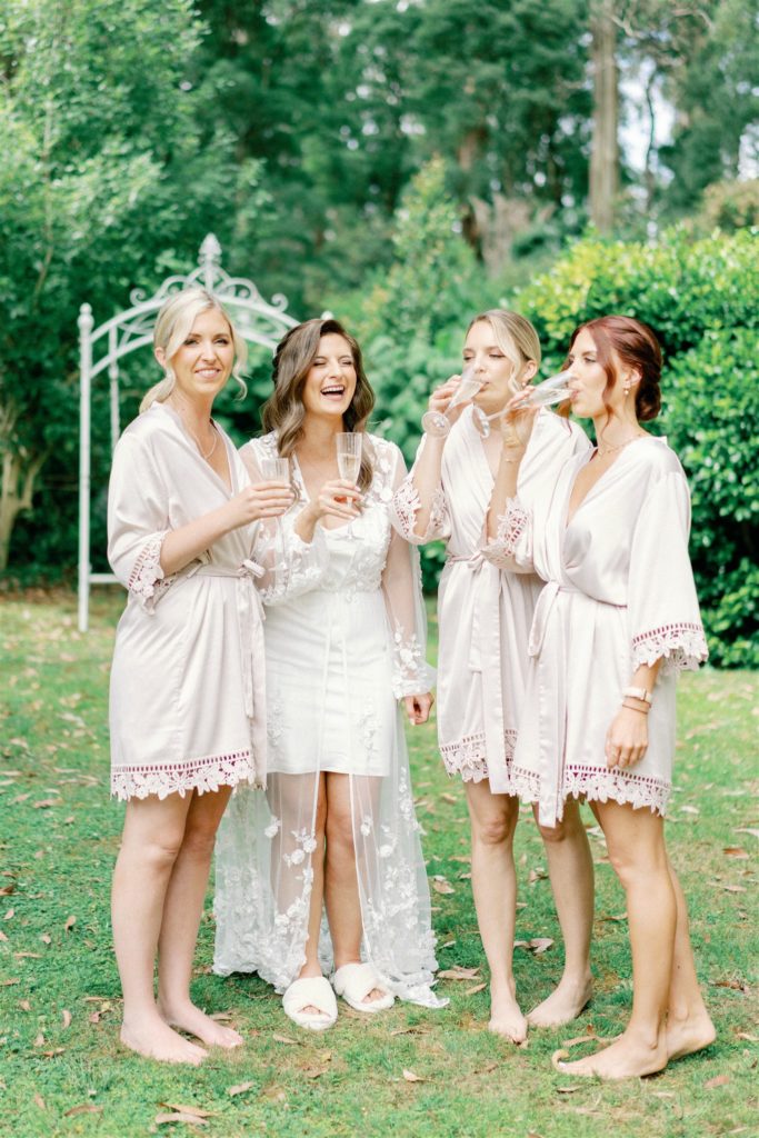 a professional wedding image of a bride drinking champagne with her bridal party