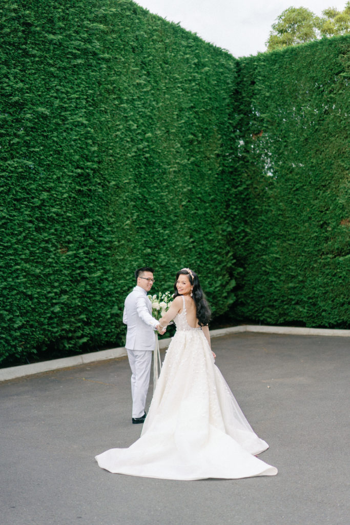 bride and groom in front of the hedges