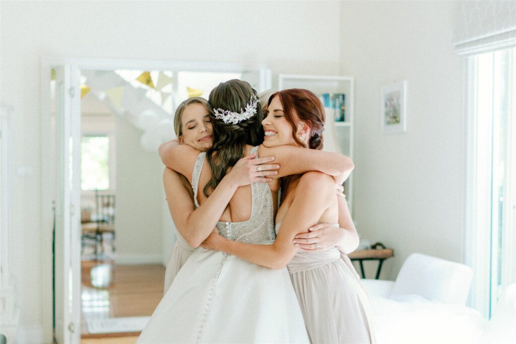 A bride embracing her bridesmaids during bridal preparations