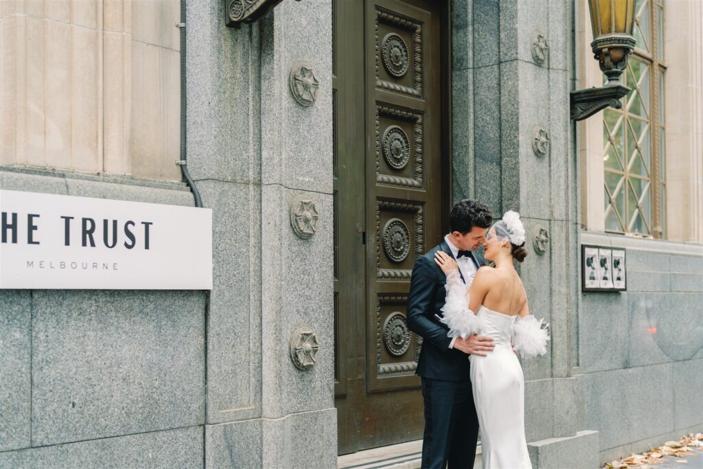 A bride and groom pose for a portrait outside The Trust in Melbourne